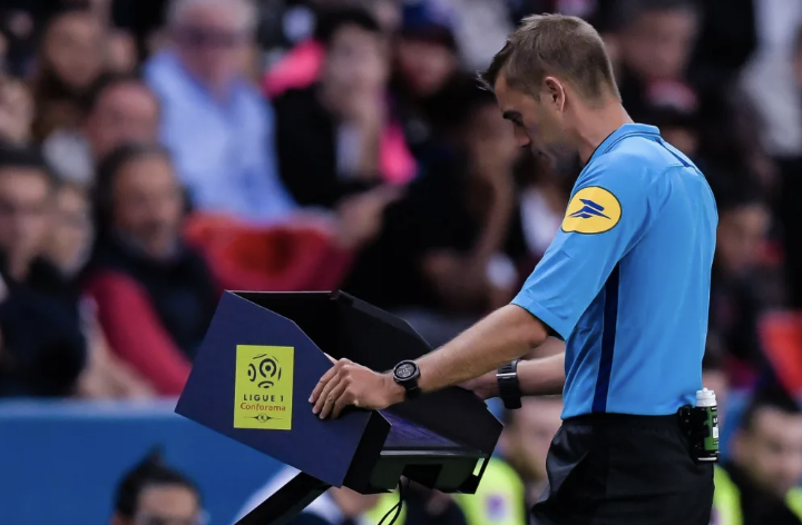 Arbitre qui consulte la VAR en Ligue 1