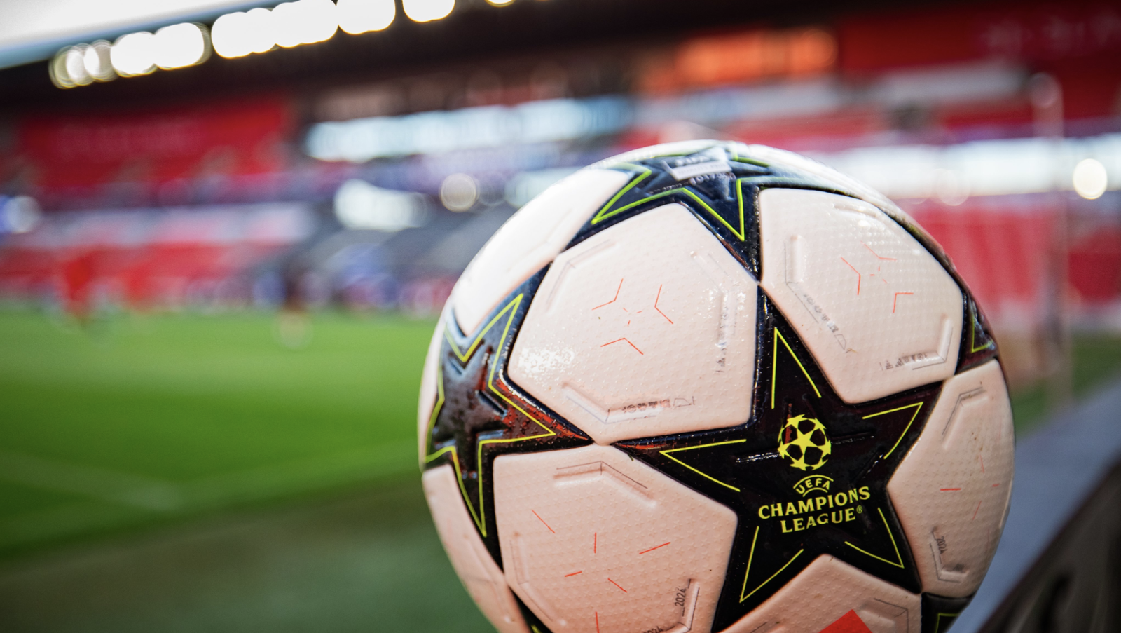 Ballon Ligue des Champions devant le terrain d’un match qui va accueillir la compétition