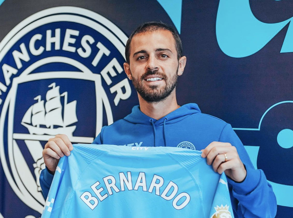 Bernardo Silva avec son maillot de manchester city à la main lors de sa signature