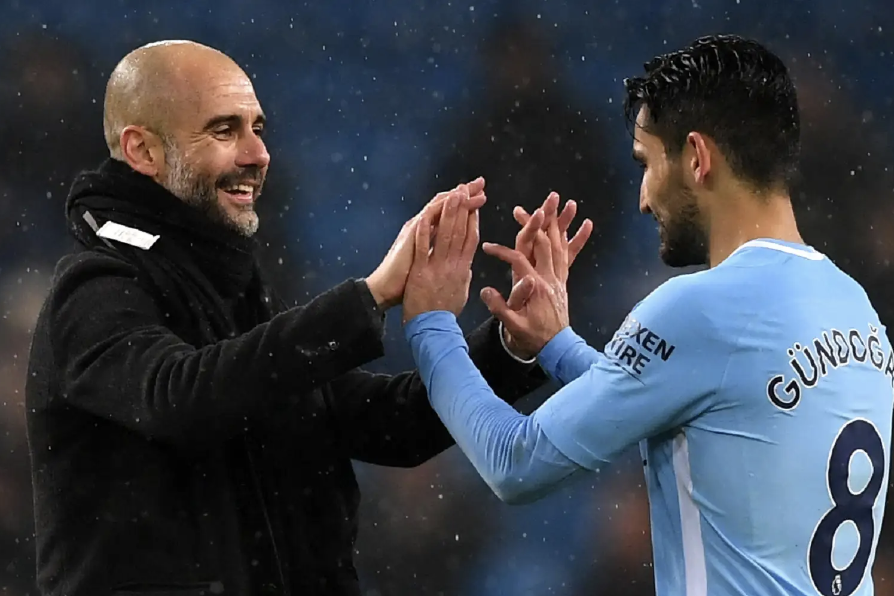 İlkay Gündoğan et Pep Guardiola se prennent les mains après la victoire de Manchester City