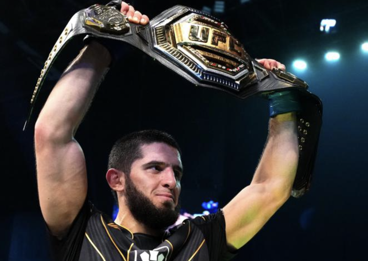 Islam Makhachev avec le sourire montre fièrement sa ceinture de champion en MMA à l’UFC