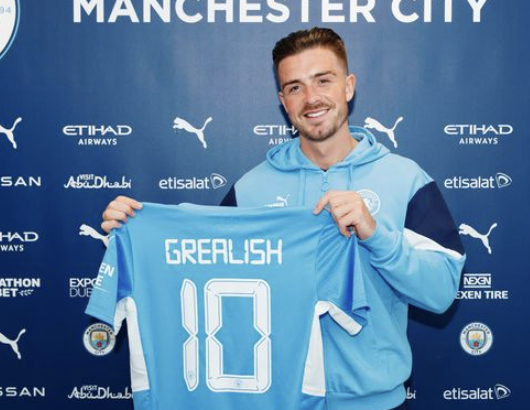 Jack Grealish qui montre son maillot avec le numéro 10 lors de sa signature avec Manchester City