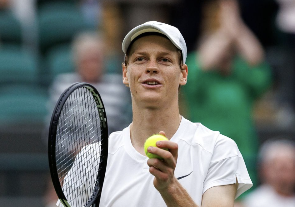 Jannik Sinner avec le sourire discute avec l’arbitre pendant un match de tennis