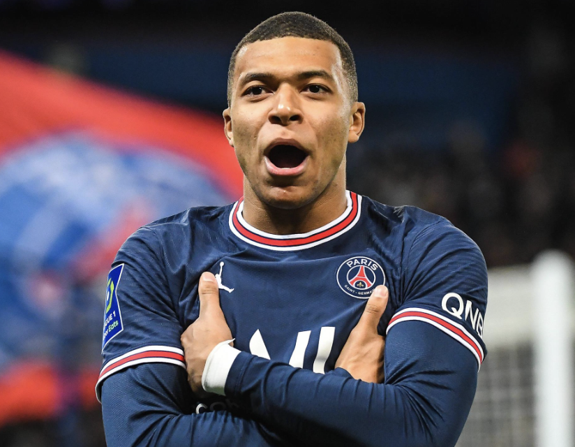 Kylian Mbappé buteur avec le Paris Sain-Germain fait sa célébration avec les bras croisés devant les supporters parisien