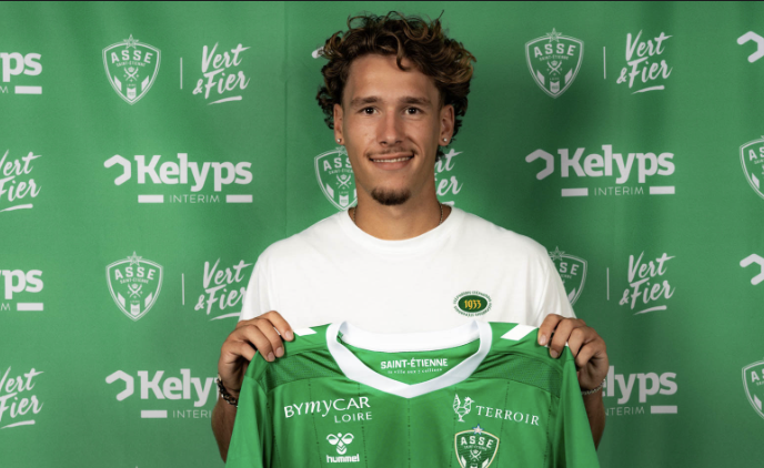 Lucas Stassin présente son nouveau maillot de l’ASSE dans ses mains lors de sa présentation