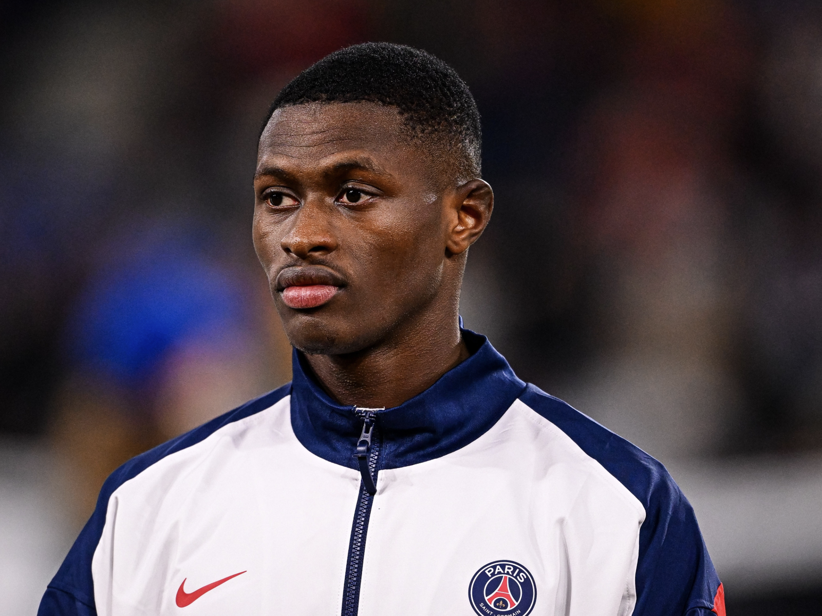 Nuno Mendes concentré avec le survêtement du PSG avant un match de football