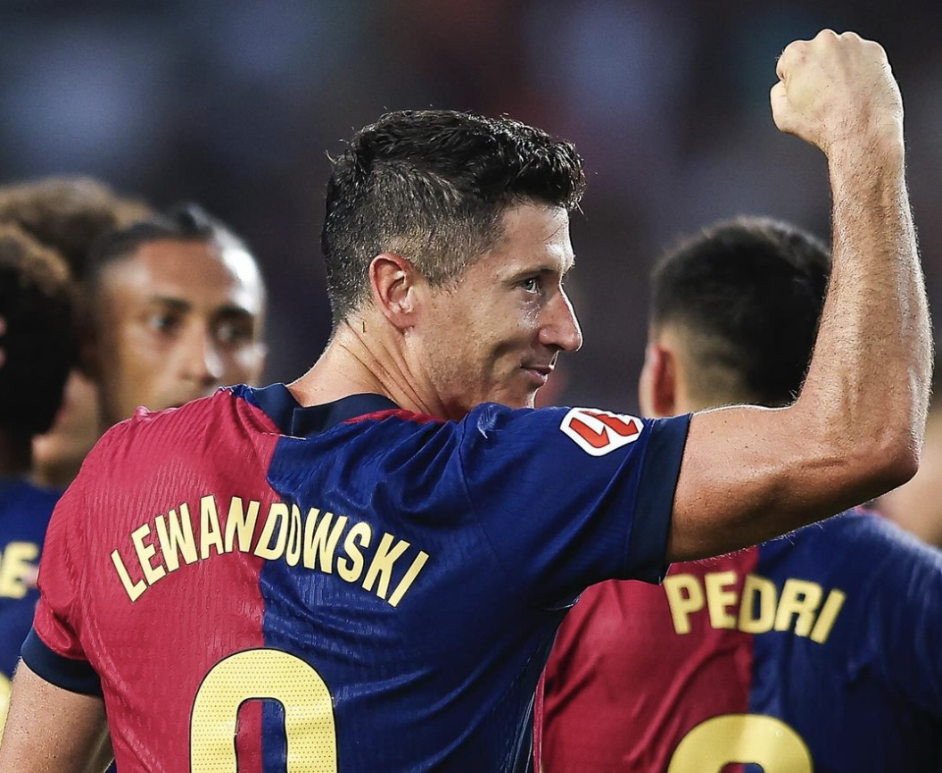 Robert Lewandowski point serré et regard vers son entraîneur du FC Barcelone Hansi Flick après un but