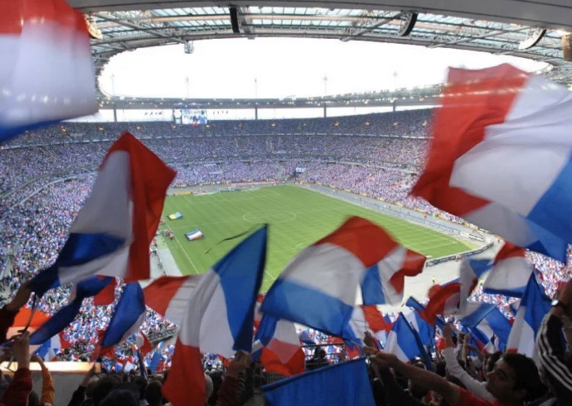 Stade de rugby avec des supporters français brandissant les drapeaux