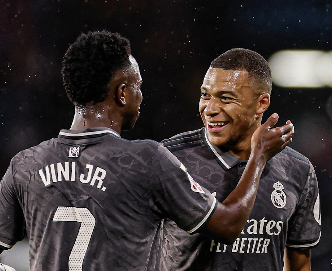 Vinicius Junior attrape Kylian Mbappé qui sourit après sa passe décisive avec le Real Madrid en Liga