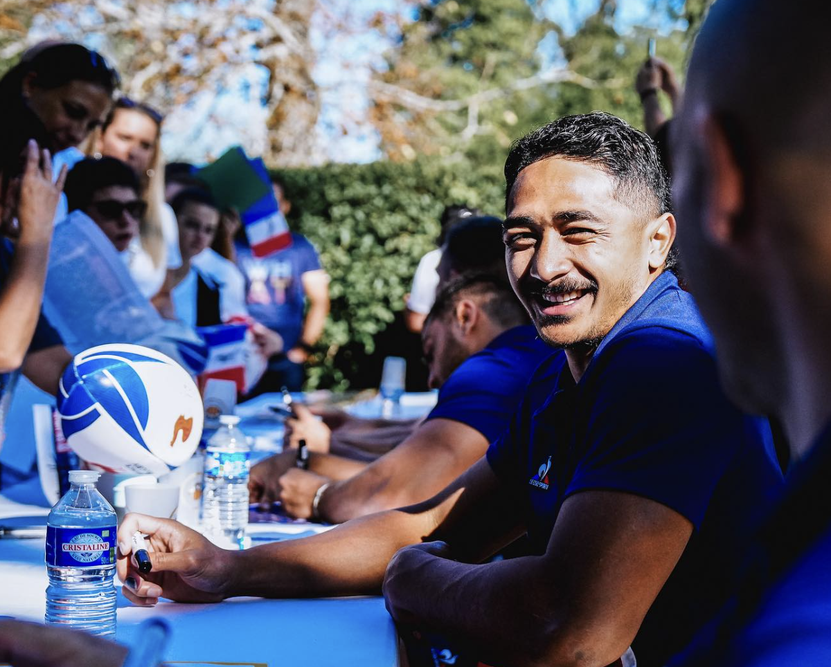 Yoram Moefana en Équipe de France de rugby qui signe des autographes